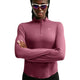 En person iført solbriller og en langærmet Nike Swift UV Half Zip-løbetrøje til kvinder i farven Pink Smoke/Reflective Silver står med armene over kors foran en hvid baggrund.