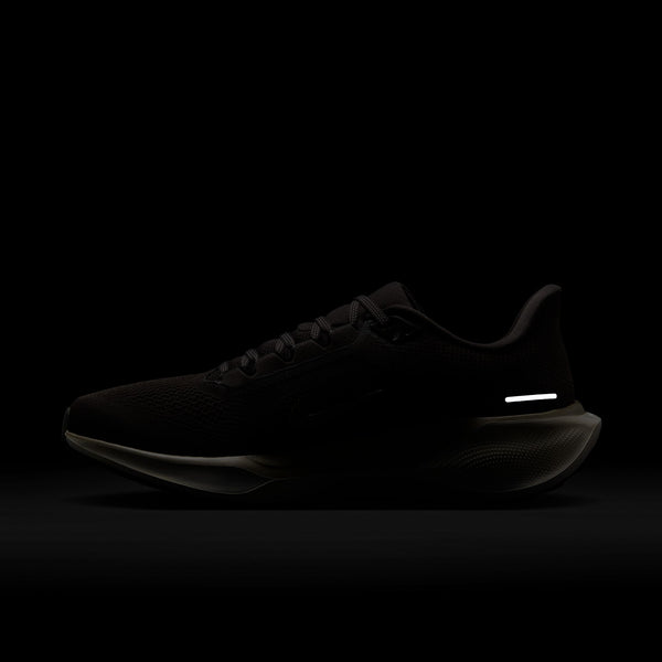 En Nike Pegasus 41 Ji løbesko, herre, i farven Medium Ash/Mtlc Gold Grain-Summit White vises mod en mørk baggrund. Den har et lavt design, mesh-overdel, refleksdetalje ved hælen og fremhævet ReactX-skum-sål.