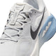 Nærbillede af Nike Structure Plus til mænd i farvekombinationen Grey Fog/Medium Ash-Summit White, med sort Swoosh, overdel i mesh samt hvid og blå mellemsål med ZoomX-logo – designet med henblik på stabilitet for at afhjælpe overpronation under løbeture.
