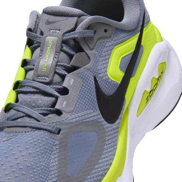 Nærbillede af en grå Nike Structure Plus Herre-løbesko til overpronation med lysegule detaljer, et sort Swoosh-logo og en hvid mellemsål.