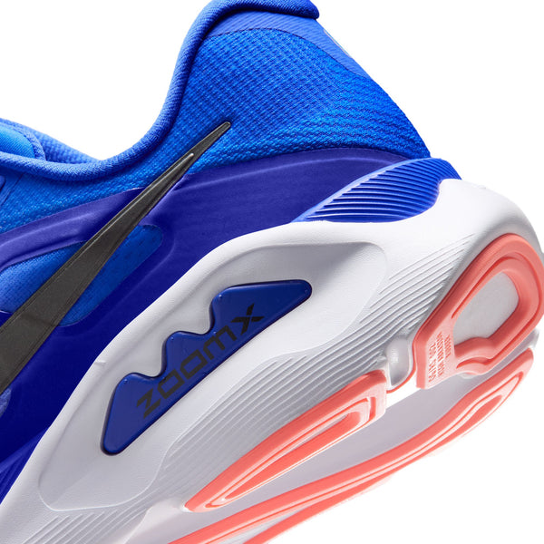 Nærbillede af hælen og sålen på Nike Structure Plus-løbeskoen til herre i farvekombinationen Racer Blue/Black-Atomic Pink-White, hvor man kan se »ZOOMX«-teksten på siden. Denne model er designet til at øge stabiliteten og yde støtte mod overpronation og har orange stødabsorberende detaljer på den hvide ydersål.