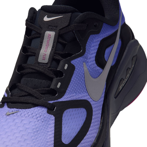 Nærbillede af Nike Structure Plus Dame-sportsskoen i sort, metallisk sølv og persisk violet med et gråt Swoosh-logo, sorte snørebånd og synligt Zoom-logo på den mørke sål. På tungen står der »SILT RED/ATLAS«.