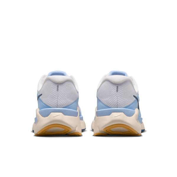 Et par Nike Structure Plus-løbesko til kvinder, set bagfra, har en hvid overdel med detaljer i farverne Mystic Navy og Aluminum, beige mellemsåler og gummifarvede ydersåler. Logoet er placeret på hver hæl for at sikre stabilitet.