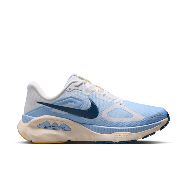Nike Structure Plus til kvinder har et design i hvid og lyseblå (Aluminum) med et Mystic Navy-swoosh, hvide snørebånd og en cremefarvet (Sundial) sål. Modellen er udviklet med henblik på stabilitet, og »zoomx« er synligt på mellemsålens side.