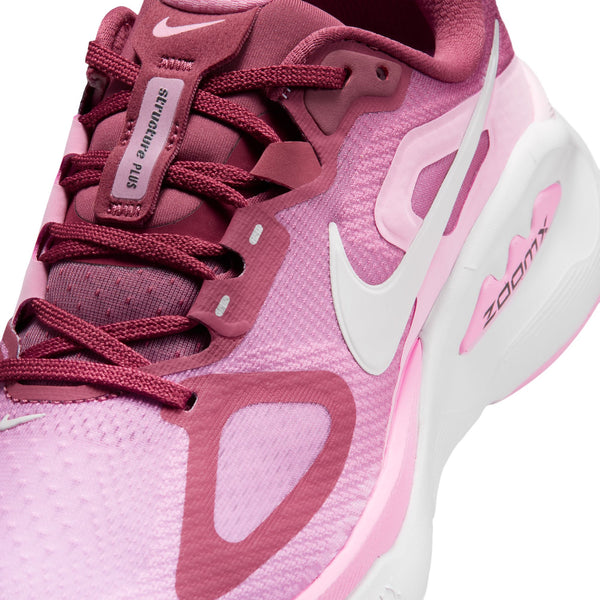 Et nærbillede af Nike Structure Plus Dame-løbeskoen i farvekombinationen Pink Smoke/White-Pink Rise-Lt Magenta, med et hvidt Swoosh-logo, ZoomX-mærkning på mellemsålen, der sikrer stabilitet, rødbrune snørebånd og optimal støtte ved overpronation.