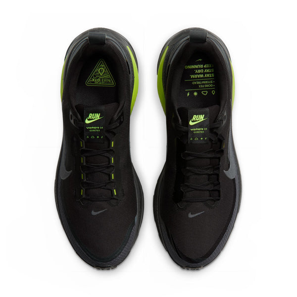 Et par Nike Vomero 18 GORE-TEX løbesko til herre i farven Anthracite/Black-Lemon Venom ses set ovenfra. Disse vandtætte løbesko har neongrønne („Lemon Venom“) detaljer, neonfarvet tekst og symboler på venstre indersål samt synlige snørebånd og de ikoniske Nike Swoosh-logoer på siderne. Ideelle til dem, der søger stilfulde, vandtætte løbesko til mænd.