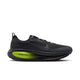 En sort Nike Vomero 18 GORE-TEX-løbesko til mænd med en overdel i antracit og sort med et gråt Nike-swoosh, sorte snørebånd og iøjnefaldende detaljer i Lemon Venom-grøn på ZoomX-mellemsålen. Skoen har en mønstret ydersål og en lav silhuet. Denne model er udviklet som en vandtæt løbesko og tilbyder fremragende ydeevne og beskyttelse til herre-løbesko i al slags vejr. Billedet er taget på en ensfarvet hvid baggrund.