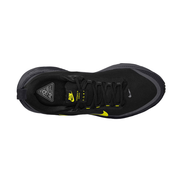 Et billede set ovenfra af Nike Vomero 18 GORE-TEX til herre i farvekombinationen Anthracite/Black-Lemon Venom viser skoens sorte mesh-overdel med sorte snørebånd, gule detaljer, et lille Nike-logo ved tåen og en detaljeret tungeetiket. Skoen har et synligt Lemon Venom-swoosh på siden og er designet til at være vandtæt, så den både leverer ydeevne og stil, hvilket gør den til et fremragende valg blandt løbesko til herre.