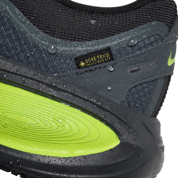 Nærbillede af hælen på en mørk Nike Vomero 18 GORE-TEX herreløbesko i farven Anthracite/Black-Lemon Venom, med iøjnefaldende limegrønne detaljer og vanddråber, der fremhæver den vandtætte GORE-TEX Invisible Fit-teknologi – hvilket gør den til det ideelle valg for alle, der søger en pålidelig, vandtæt løbesko, perfekt til overlegen komfort og beskyttelse i al slags vejr.