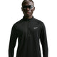 En person iført mørke solbriller og en sort Nike Stride Half Zip Midlayer løbetrøje (Herre, Sort/Reflekterende Sølv) står med ansigtet vendt fremad foran en ensfarvet hvid baggrund og fremviser en elegant herretræningsstil.