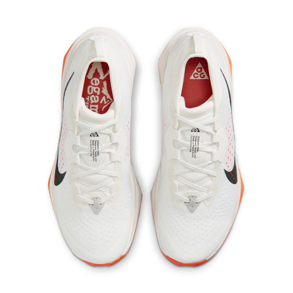 Nike ACG Zegama Herre i Summit White/Black-Phantom-Safety Orange har overdel i hvidt mesh, sorte swoosh-logoer, orangefarvede såler, rødt branding på indersålen, hvide snørebånd og Vibram Megagrip-ydersåler med godt greb.