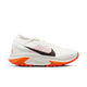 En Nike ACG Zegama herre trail løbesko i Summit White/Black-Phantom-Safety Orange med mesh-overdel, sort swoosh og Vibram Megagrip-sål, vist fra siden på hvid baggrund.