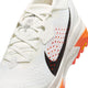 Nærbillede af Nike ACG Zegama trailsko til mænd i Summit White/Black-Phantom-Safety Orange med sort swoosh, Vibram Megagrip-sål, orange detaljer, perforeret overdel, hvide snørebånd og synlig tekst på tungen.