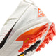 Nærbillede af hælen og sålen på Nike ACG Zegama Herre i Summit White/Black-Phantom-Safety Orange, der fremhæver Vibram Megagrip-logoet, den strukturerede slidbane og det geometriske design på overdelen.