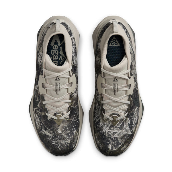 Et par Nike ACG Zegama trail-løbesko til herre i farven Spruce Fog/Black Spruce-Sea Glass-Black, set ovenfra. Skoene har hvide snørebånd, et synligt Nike ACG-logo på tåkapen og er udstyret med Vibram Megagrip-såler, der sikrer suverænt greb på udfordrende underlag.