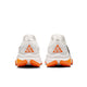 Et par Nike ACG Zegama Dame trailsko i Summit White/Black-Phantom-Safety Orange, vist bagfra med orange og hvide trekantede ACG-hæl-logoer, orange såldetaljer og koordinater trykt på mellemsålerne.