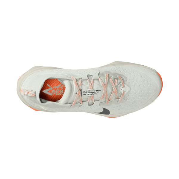 Nike ACG Zegama Dame trailsko i Summit White/Black-Phantom-Safety Orange med orange detaljer, mønstrede snørebånd, synligt Nike-logo, orange Zoom-indlægssål og Vibram Megagrip-ydersål set oppefra.