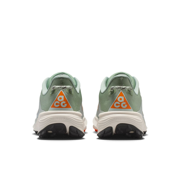 Et par Nike ACG Pegasus Trail damesko i Jade Horizon/Phantom-Light Silver, vist bagfra med et orange ACG-logo på hælen og hvide ReactX-skum-mellemsåler på en hvid baggrund.