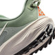 Nærbillede af hælen på en Nike ACG Pegasus Trail Dame i Jade Horizon/Phantom-Light Silver, der viser struktureret stof, en løkke bagpå, orange mærkevaredetaljer og en robust sort og hvid sål med dybe slidbaner.