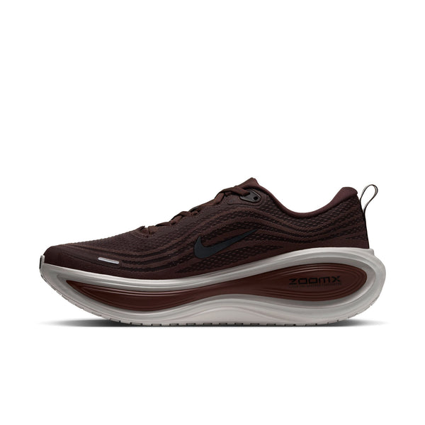 Nike Vomero Plus-løbesko i farverne Baroque Brown og Black, med en tyk, lagdelt mellemsål i beige og brunt samt et sort Swoosh-logo på siden.