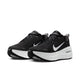 Et par Nike Vomero Plus Dame-løbesko i farvekombinationen Sort/Hvid-Cool Grey-Mtlc Mørkegrå, med hvide såler og hvide Nike Swoosh-logoer på siderne samt teksten »ZOOMX« trykt tæt ved hælen for maksimal komfort. Skoene står side om side og vender let mod venstre.