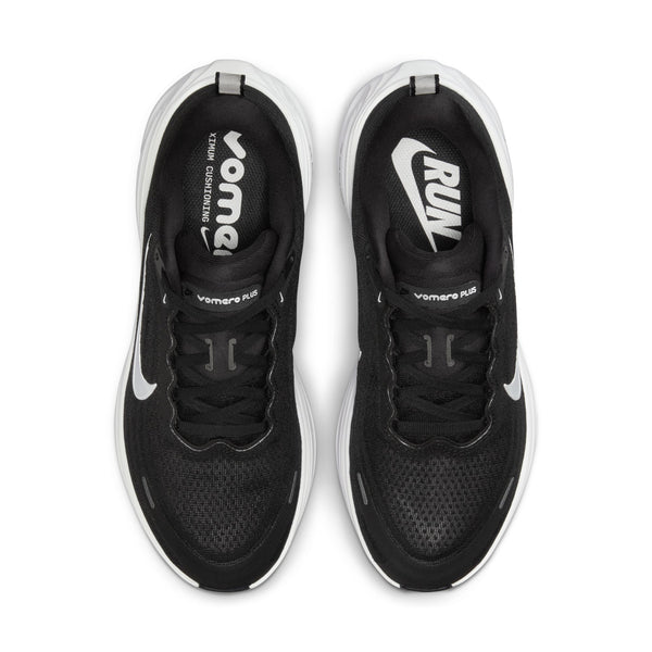 Oversigtsbillede af Nike Vomero Plus Dame-løbeskoen i farvekombinationen Sort/Hvid-Cool Grey-Mtlc Mørkegrå. Hver sko er udstyret med synlige Nike-swooshes og slanke hvide mellemsåler med stilfulde hvide detaljer. Indvendigt er der trykt »vomero« på venstre sko og »RUN« på højre, hvilket sikrer maksimal komfort ved hvert skridt.