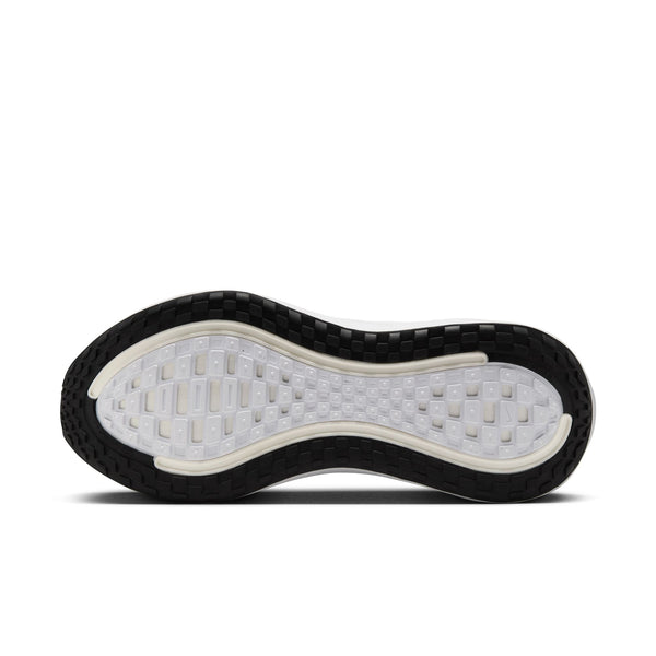 Billedet viser undersiden af Nike Vomero Plus Dame-sålen i farvekombinationen Sort/Hvid-Cool Grey-Mtlc Mørkegrå. Mønsteret består af hvide og halvgennemsigtige sektioner med sort gummi langs kanterne, hvilket sikrer fremragende vejgreb og greb for maksimal komfort.