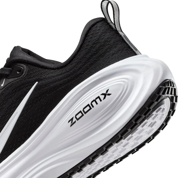 Nærbillede af hælen og sålen på en Nike Vomero Plus Dame i farvekombinationen Sort/Hvid-Cool Grey-Mtlc Mørkegrå, hvor den hvide mellemsål med påskriften »ZOOMX« på siden ses tydeligt. Ydersålen har et struktureret mønster, der sikrer maksimal komfort og greb.