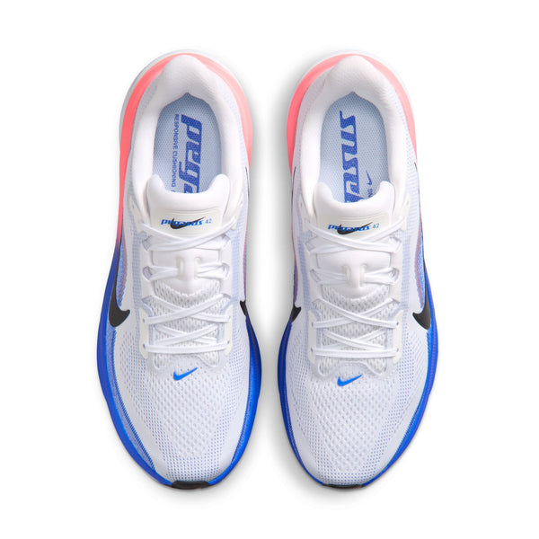 Et par Nike Pegasus 42 løbesko til mænd i farvekombinationen Hvid/Sort-Racerblå-Atomic Pink set ovenfra. Den venstre sko har detaljer i Racerblå, mens den højre har detaljer i Atomic Pink. Begge sko har sorte Nike Swoosh-logoer og teksten »PEGASUS 42« og »RUN« på indersålerne. Disse sko er udviklet med fokus på komfort og ydeevne og er udstyret med en ReactX-skummesål, der giver responsiv støddæmpning, samt en Air Zoom-enhed, der forbedrer hvert skridt.