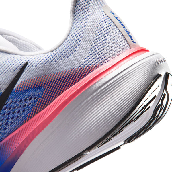 Nærbillede af hælen på en Nike Pegasus 42 Herre-løbesko i farvekombinationen Hvid/Sort-Racerblå-Atomic Pink, der viser den hvide og blå mesh-overdel med en accentstribe i Atomic Pink. Den strukturerede hvide ydersål har et sort mønster, mens ReactX-skum-mellemsålen og Air Zoom-teknologien er sømløst integreret for øget komfort og ydeevne.