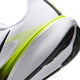 Nærbillede af hælen og sålen på Nike Pegasus 42 (Herre) i farvekombinationen HVID/SORT-LEMON VENOM-HVID, der viser en mellemsål med ReactX-skum, sorte og gulgrønne striber, en overdel i struktureret stof samt en sort ydersål i gummi.
