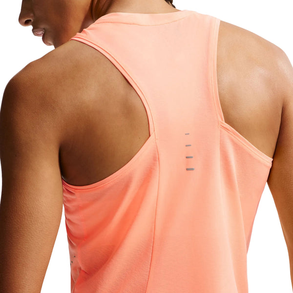 En kvinde ses bagfra iført en ærmeløs Nike Nk Swift Nvlt Brthe Tank i Orange Pulse/Photon Dust med refleksstriber over den øverste del af ryggen.