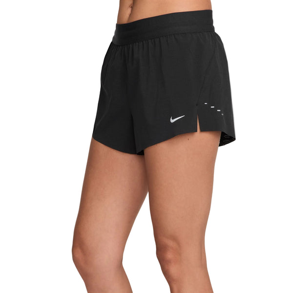 Modellen er iført Nike Swift Breathe Mid-Rise 2.5" løbeshorts i sort/hvid med et hvidt Nike-logo på venstre ben - ideelle til komfortable og stilfulde løbeture. Vist fra talje til midt på låret mod en ensfarvet hvid baggrund.