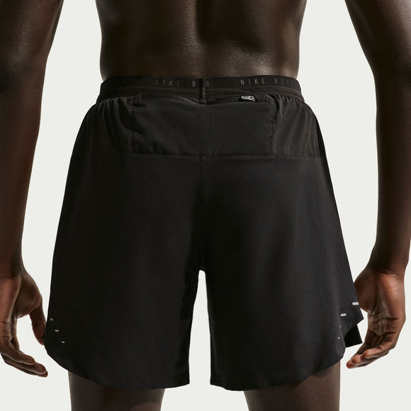 En person ses bagfra iført Nike Nk Df Stride 2In1 7In herre shorts i sort/reflekterende sølv, med en bred linning og små reflekterende detaljer i bunden, som fremhæver disse komfortable træningsshorts.