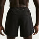 En person ses bagfra iført Nike Nk Df Stride 2In1 7In herre shorts i sort/reflekterende sølv, med en bred linning og små reflekterende detaljer i bunden, som fremhæver disse komfortable træningsshorts.