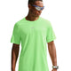 En person iført reflekterende solbriller, en neongrøn Nike Stride Aero-FIT kortærmet løbetrøje til mænd i farverne Volt/Light Silver/Reflective Silver – kendt for sin optimale ventilation – samt et smartur står foran en hvid baggrund og kigger til siden.