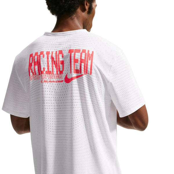 En mand bærer Nk Dfadv Aeroswift Gfx Ss løbetrøje herre fra Nike i Summit White, med RACING TEAM og en rød swoosh på ryggen, lavet med Dri-FIT ADV-teknologi for topkomfort.