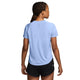 Der ses en person med flettet hår set bagfra, iført en lyseblå Nike Swift Aero-FIT kortærmet løbetrøje til kvinder i farverne Aluminium/Pure Platinum/Reflective Silver samt sorte shorts. Baggrunden er ensfarvet hvid.