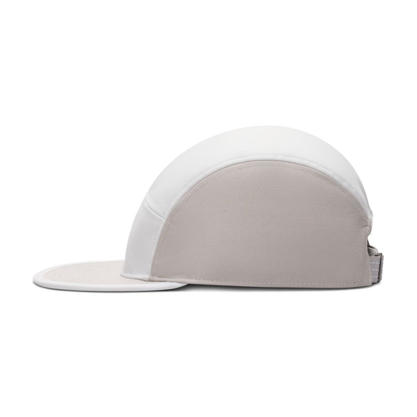 Nike ACG Fly Cap i Photon Dust/College Grey har en afrundet krone, flad skygge og strop bagpå. Denne unisex-kasket er lavet af vandafvisende materiale og er vist fra siden på en hvid baggrund.