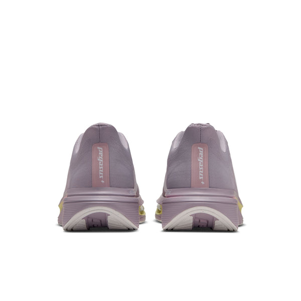 Et par Nike Pegasus Plus 2-løbesko til kvinder i farven SILVER LILAC/SAIL-PARTICLE ROSE-FENNEL ses set bagfra på en hvid baggrund. Skoene har hvide såler fremstillet af det responsivt ZoomX-skum og et lille lyserødt logo ved hælen.