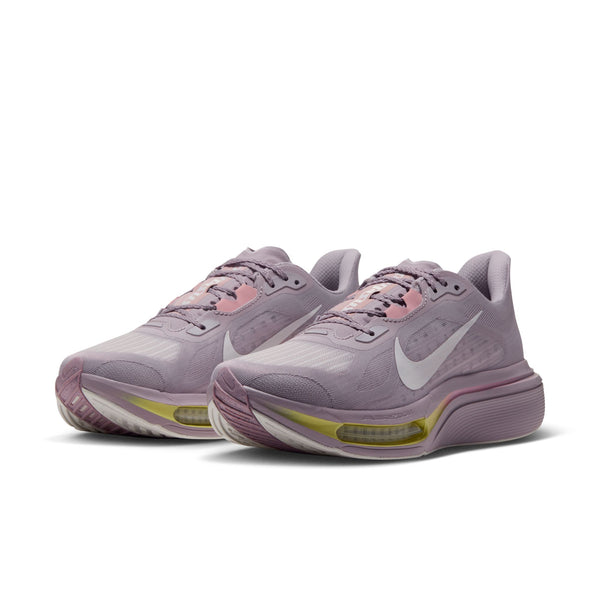 Et par Nike Pegasus Plus 2 løbesko til kvinder i farvekombinationen SILVER LILAC/SAIL-PARTICLE ROSE-FENNEL, med hvide Nike-swooshes, lyserøde og gule detaljer, åndbare mesh-detaljer og tykke såler med responsiv ZoomX-skum-støddæmpning, placeret side om side på en hvid baggrund.