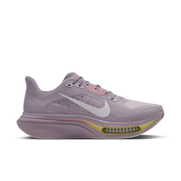 En Nike Pegasus Plus 2 løbesko til kvinder i farven SILVER LILAC/SAIL-PARTICLE ROSE-FENNEL, med et hvidt Nike-swoosh, gule detaljer tæt på sålen og synlig Air-stødabsorbering i hælen. Skoen har en åndbar mesh-overdel og en tyk, støttende sål, der er forbedret med ZoomX-skum for responsiv komfort.