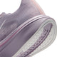 Nærbillede af siden og sålen på en Nike Pegasus Plus 2-løbesko til kvinder i farvekombinationen SILVER LILAC/SAIL-PARTICLE ROSE-FENNEL, der fremhæver ZoomX-skumstøddæmpningen i den hvide og lyserøde sål, med strukturerede detaljer på siden og et markant mønster på sålen.