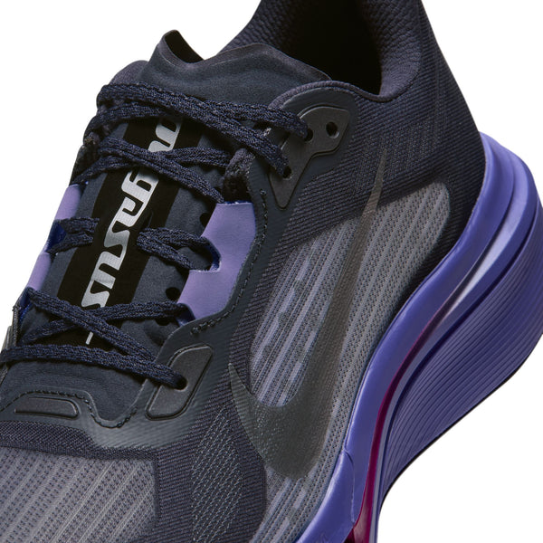 Nærbillede af en mørkegrå Nike Pegasus Plus 2-løbesko i farvekombinationen GRIDIRON/METALLIC SILVER-PERSIAN VIOLET med en lilla mellemsål og en sort tunge med påskriften Pegasus.