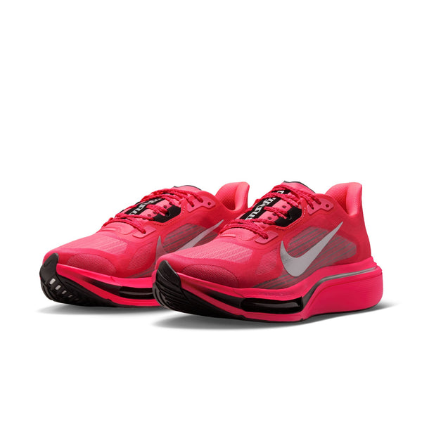 Et par Nike Pegasus Plus 2 løbesko til kvinder i farvekombinationen Flash Crimson/Metallic Silver-Black, med en markant lyserød overdel med hvide Swoosh-logoer, sorte detaljer og tykke såler udstyret med responsiv ZoomX-skumstøddæmpning – præsenteret på en ensfarvet hvid baggrund kombinerer disse sko på perfekt vis stil og ydeevne.