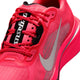 Et nærbillede af Nike Pegasus Plus 2 til kvinder i farvekombinationen Flash Crimson/Metallic Silver-Black viser en lyserød mesh-overdel med et hvidt Swoosh-logo, røde snørebånd og et sort-hvidt mærke på tungen. Den fluorescerende lyserøde mellemsål er udstyret med responsiv ZoomX-skum-støddæmpning, der sikrer enestående komfort.