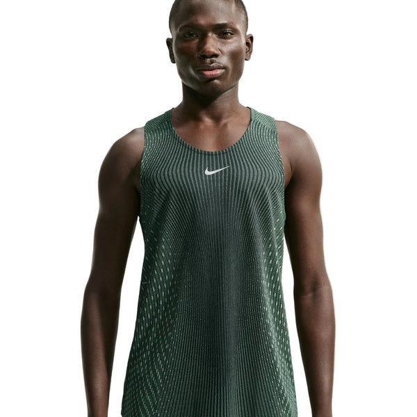 En person står foran en hvid baggrund iført en Nike Aero-FIT løbetop til mænd i farvekombinationen sort/lysegrøn spark/reflekterende sølv med et hvidt Nike-logo på brystet. Denne letvægts løbetop er designet til maksimal ventilation og sikrer komfort under alle løbeture.