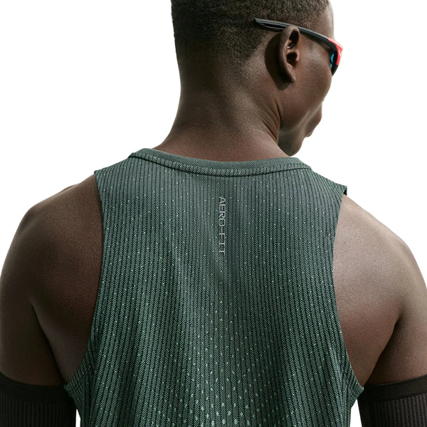 Der vises et billede bagfra af en person, der bærer Nike Aero-FIT Running Tank Top, Herre i farverne sort/lysegrøn Spark/reflekterende sølv – en let løbetrøje i mesh, der er designet til maksimal ventilation. Personen har kort hår, bærer armvarmere og solbriller, og teksten »AERO FIT« ses på ryggen på en ensfarvet hvid baggrund.