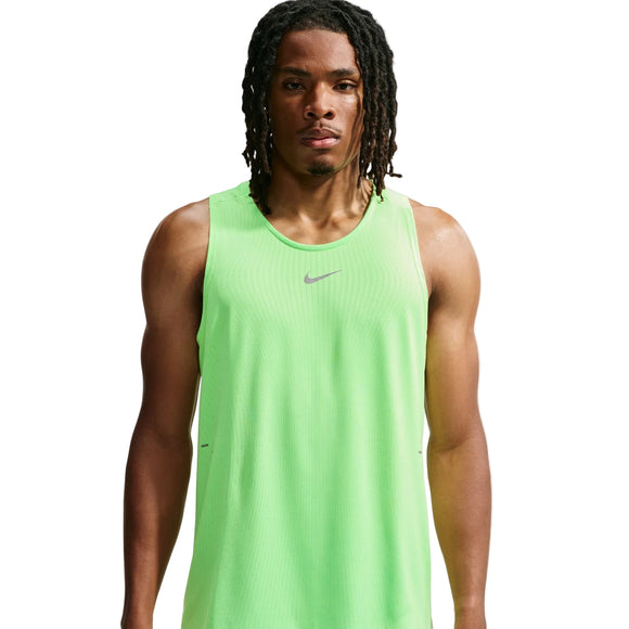 En mand med mellemlange dreadlocks har en Nike Aero-FIT løbetanktop til mænd i farverne Volt/Light Silver/Reflective Silver på, der er designet til maksimal ventilation. Han står foran en ensfarvet hvid baggrund med et neutralt udtryk i ansigtet.