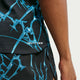 Et nærbillede af en person, der bærer Nike AeroSwift Printed Running Singlet, Herre, i sort/hvid, med blå abstrakte mønstre og teksten »DRI-FIT ADV« trykt i hvidt på trøjen.